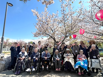 さくらサポート24 通所介護サービス 桜を背景に皆さんで記念撮影